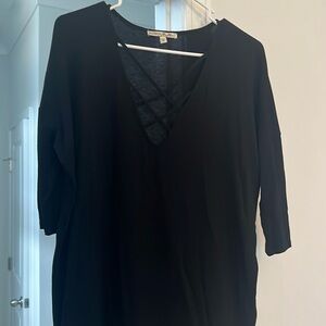 Black fitted sleeve, loose body, black top with detail.
